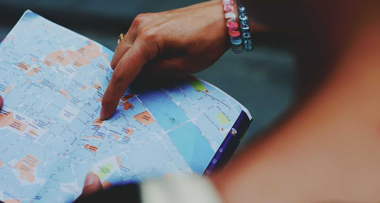 A woman’s hand pointing at a map.